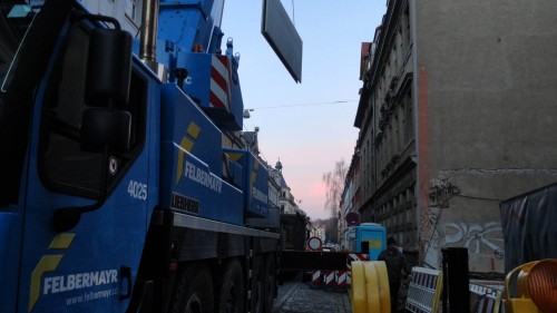 Mit schwerem Gerät werden die Platten für den Neubau transportiert.