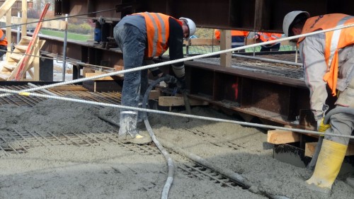 Über Schläuche wird der Beton eingegossen und dann mit Rüttelflaschen verdichtet. Foto: W. Schenk