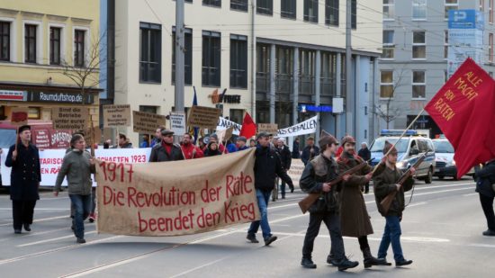 Demo mit Waffen und Transparenten.