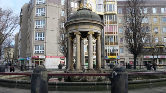 Artesischer Brunnen mit Wasserbecken.