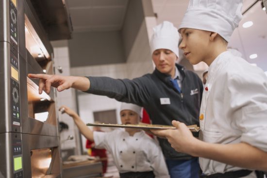 Rein in den Ofen - unter Anleitung haben die Kinder selbst gebacken - Foto: PR/Denise Kamps