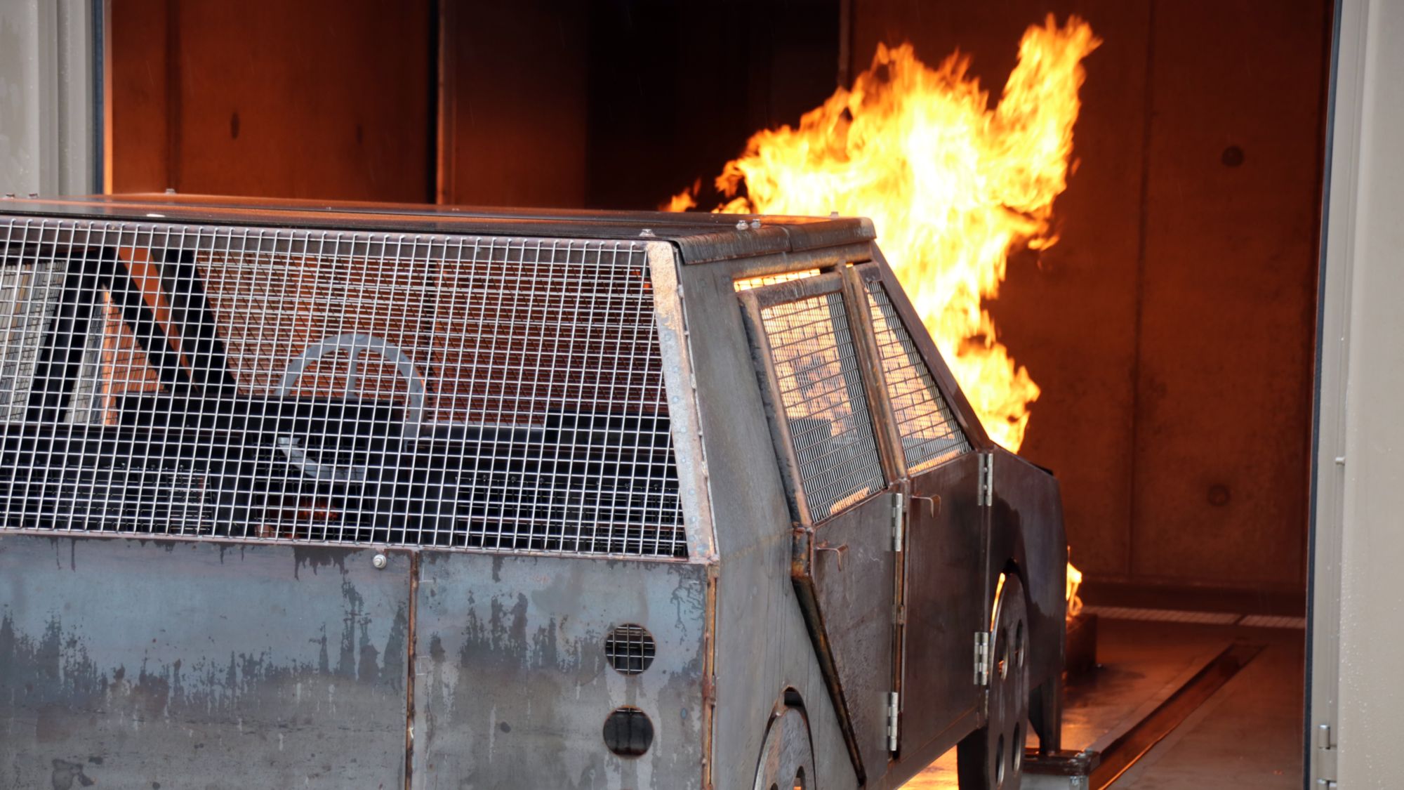 Das Auto in der Garage brennt.