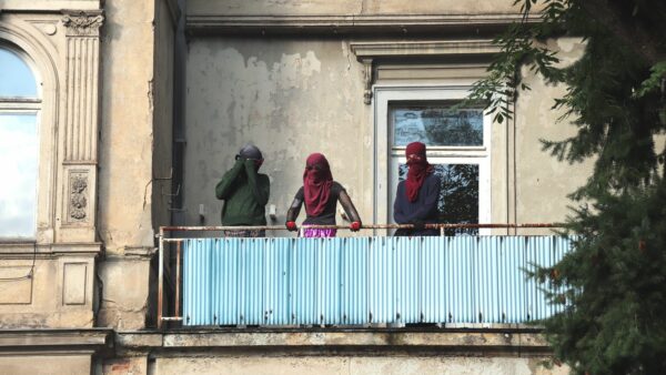 Hausbesetzer*innen auf dem Balkon