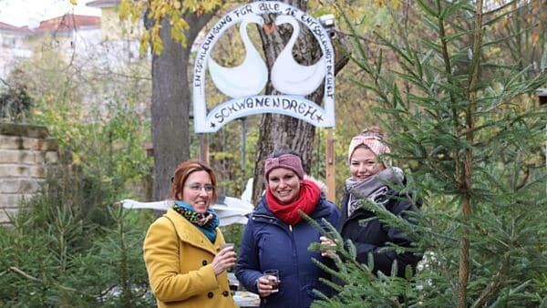 Die Anwohnerinnen Janet, Christine und Antonia proben schon mal den Glühwein. Gemeinsam mit den übrigen Anwohner*innen haben sie den Weihnachtsmarkt vorbereitet.