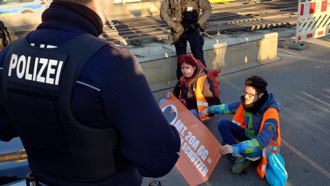 Straßenblockade der "Letzten Generation" auf der Hansastraße am Bahnhof Neustadt.