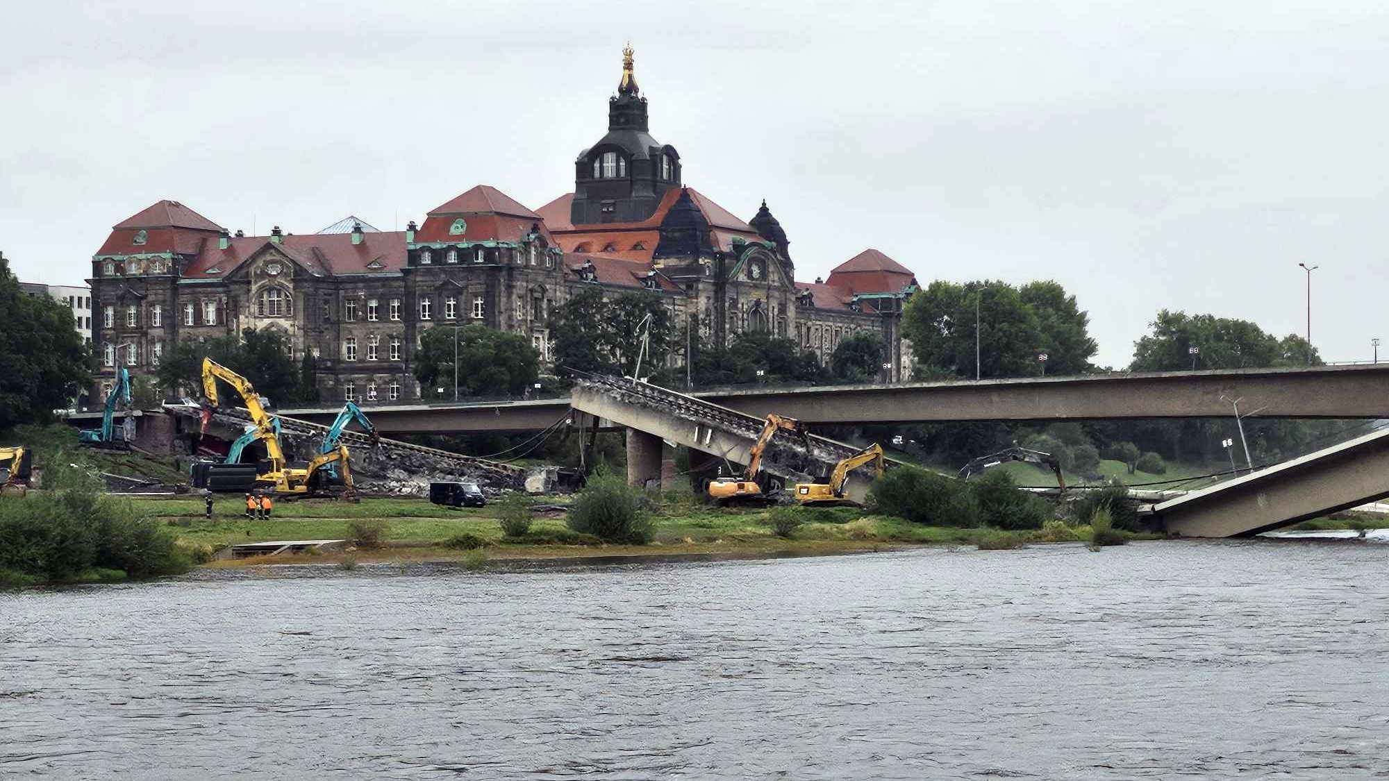 Seit dem frühen Morgen sind die Arbeiter dabei, die heruntergestürzten Brückenteile zu zerkleinern, um sie dann abzutransportieren. Foto: Christoph Springer