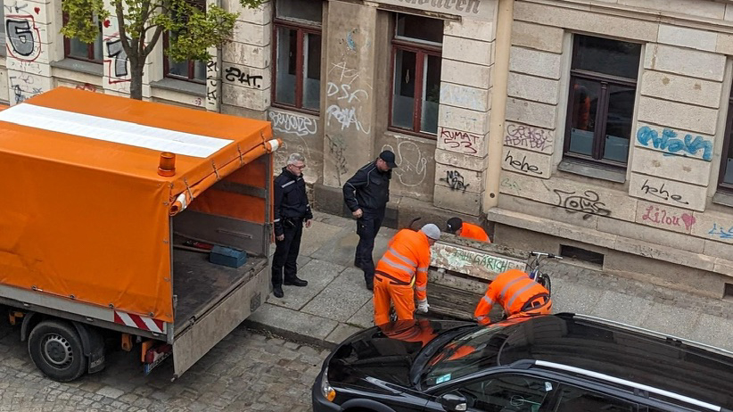 Der Fahrradanhänger mit der Aufschrift "Fahrgärtchen" wird unter den wachsamen Augen der Behörden entfernt. Foto: Privat