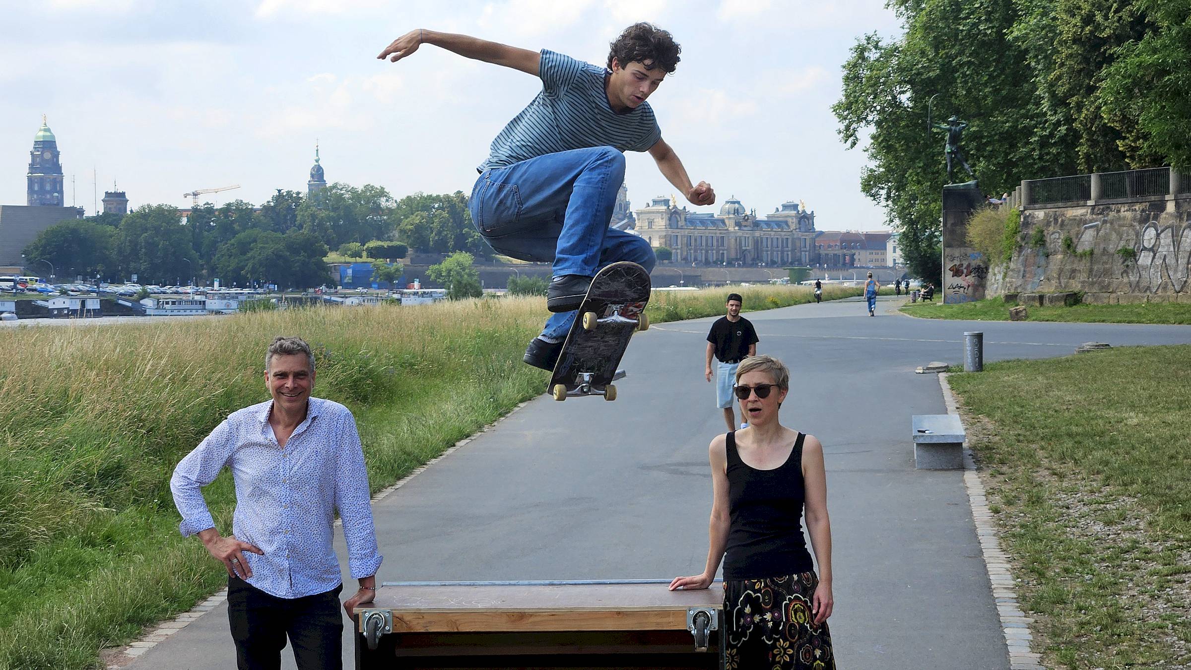 Skater Tillmann Steglich in Aktion unterhalb der Albertbrücke – im Hintergrund die Brühlsche Terrasse. Vorne: Stadtbezirksbeirätin Katja Lehmann und Landtagsabgeordneter Thomas Löser (beide Grüne). Foto: Anton Launer