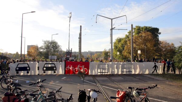Morgendlicher Protest von Radfahrer*innen am Carolaplatz. Mit dem Banner will der ADFC symbolisieren, wie er sich die stadtwärtige Fahrbahn der Carolabrücke wünscht. Foto: Anton Launer